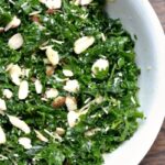 A bowl of kale salad with almond slices