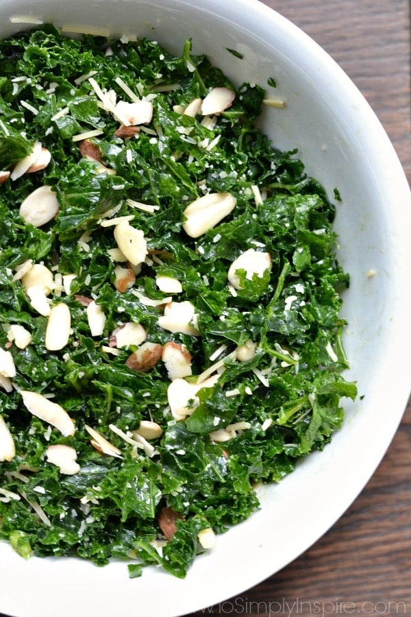 Simple Kale Salad with Lemon Vinaigrette - a healthy lunch or dinner for a busy night. Added sliced almonds and parmesan cheese pair perfectly with the tangy lemon dressing. A bowl of kale salad with slices of almonds