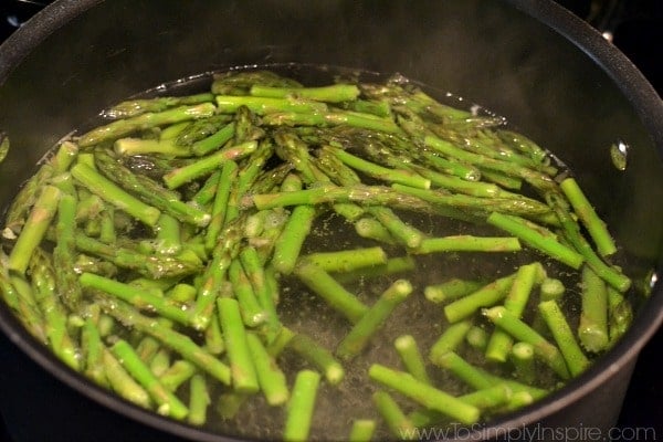 sliced asparagus cooking in a black pan