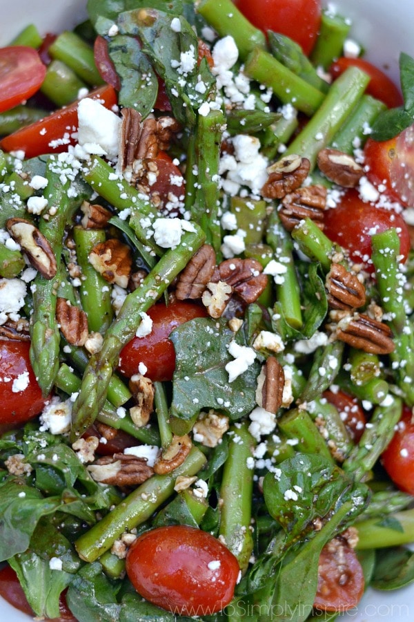 closeup of a salad with asparagus, tomatoes, feta cheese and pecans