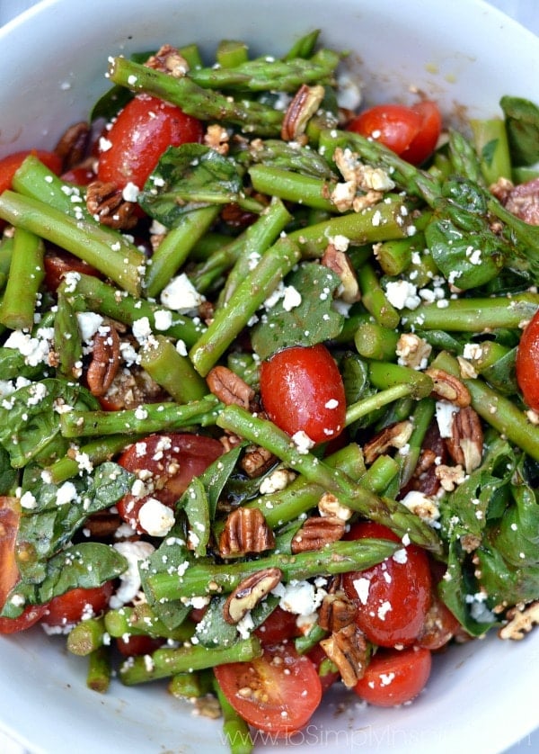 a bowl of spinach, asparagus and tomato salad