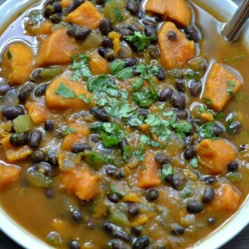 A bowl of sweet potato black bean soup in a white bowl