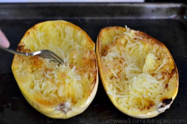 Two spaghetti squash halves with a fork in one