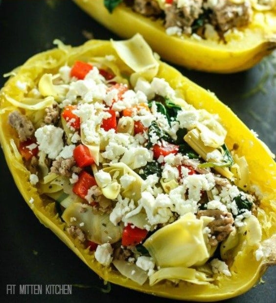 spaghetti squash half covered with feta cheese, artichokes and tomatoes 