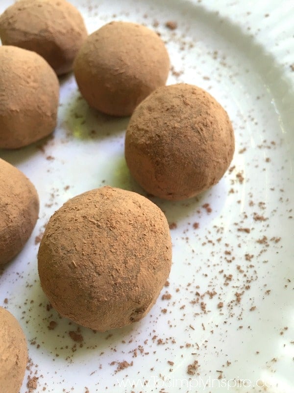 cocoa covered chocolate truffles on a white plate