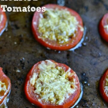 closeup of two tomatoe slices with parmesan cheese and pesto on top