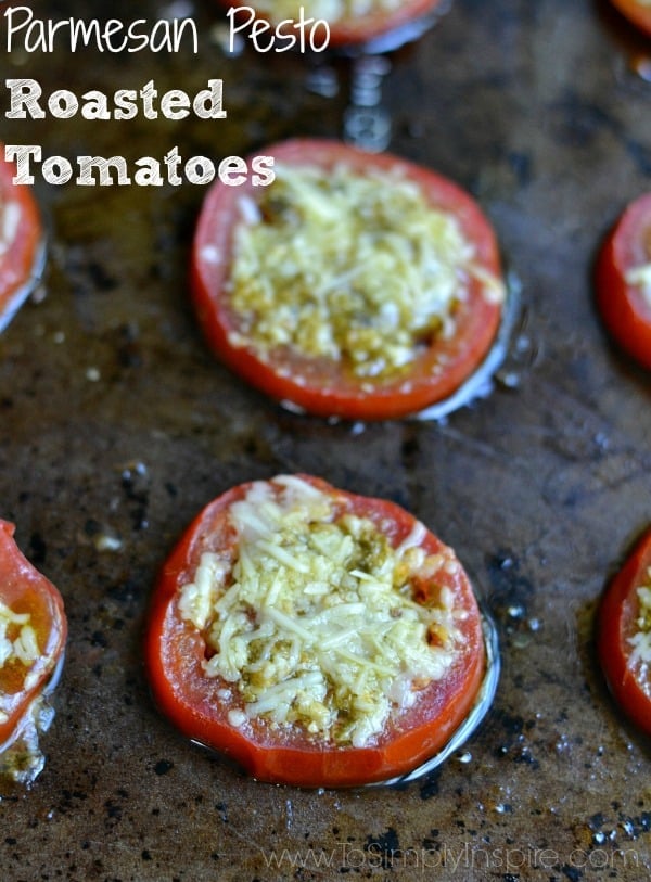 closeup of two tomatoe slices with parmesan cheese and pesto on top