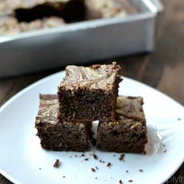 a stack of three brownies on a white plate