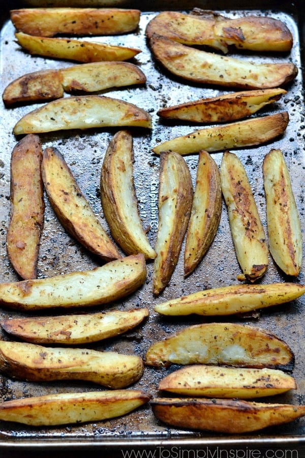 a baking sheet full of cooked potato wedges