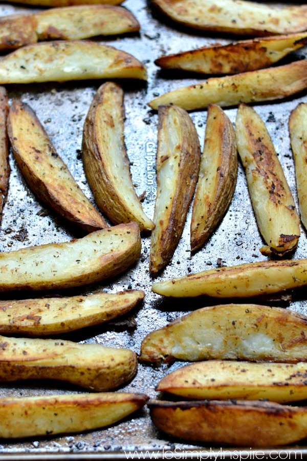 potato wedges cooking on a baking sheet