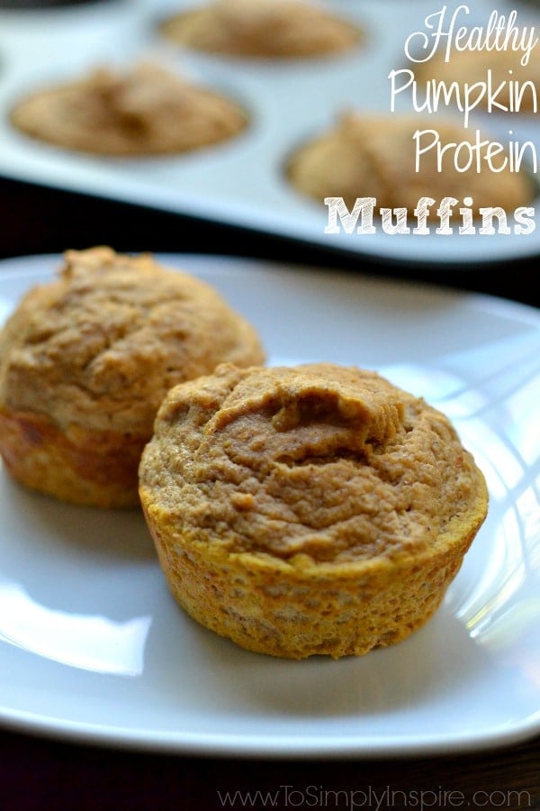 closeup of two pumpkin muffins on a white plate with text overlay - pumpkin protein muffins