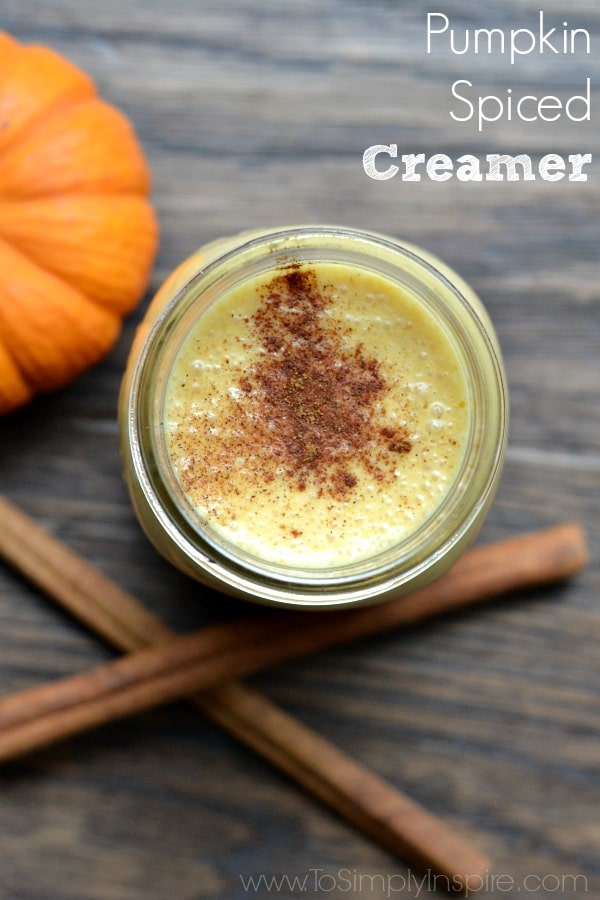 overhead of pumpkin creamer in a mason jar with cinnamon sticks and small pumpkin