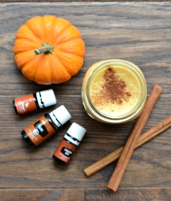 pumpkin creamer in a mason jar with cinnamon sticks and small pumpkin with essential oils