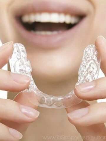 A close up of a woman holding invisible aligners in her hands
