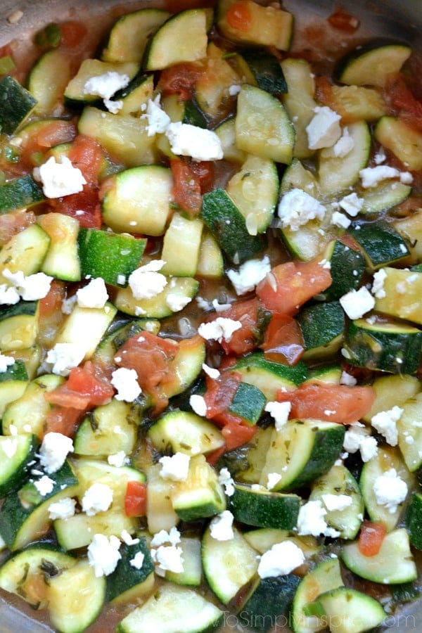 A pan of zucchini, feta cheese and diced tomatoes
