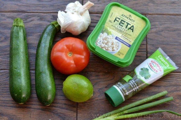 Food on a wooden cutting board with Lime and feta cheese container