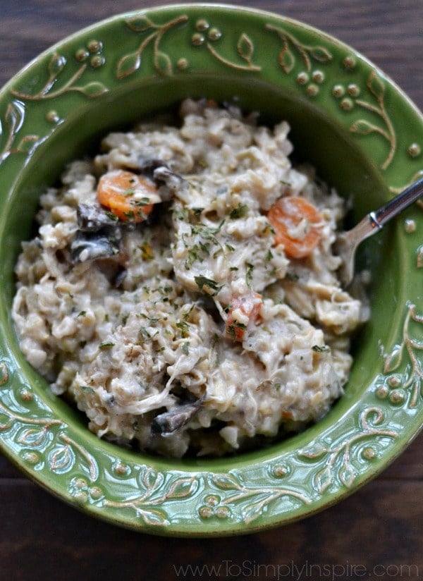 green bowl full of chicken and rice casserole with carrots and mushrooms