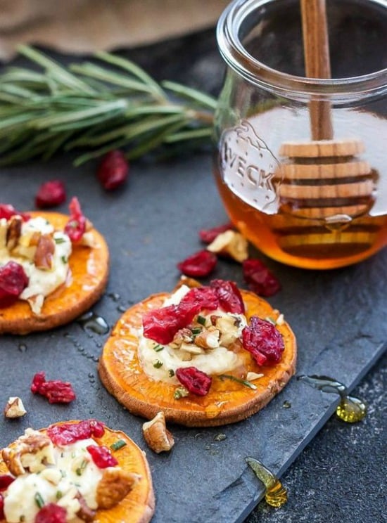 A close up of sweet potato bites topped with cranberries and pecans