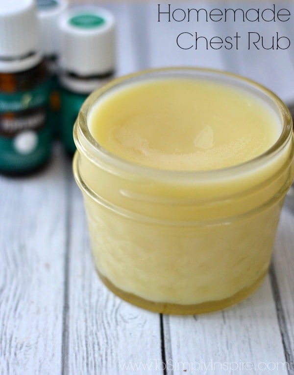 a small mason jar with homemade chest rub with essential oil bottles in the background