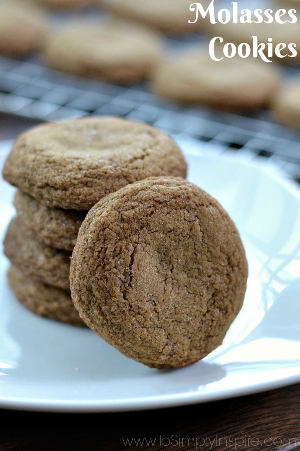 Crispy on the outside and soft on the inside, these Molasses cookies will literally melt in your mouth. They are a wonderful spiced cookie to add to your family favorites and holiday baking. Four molasses cookies on a white plate with one leaning against the stack on a white plate