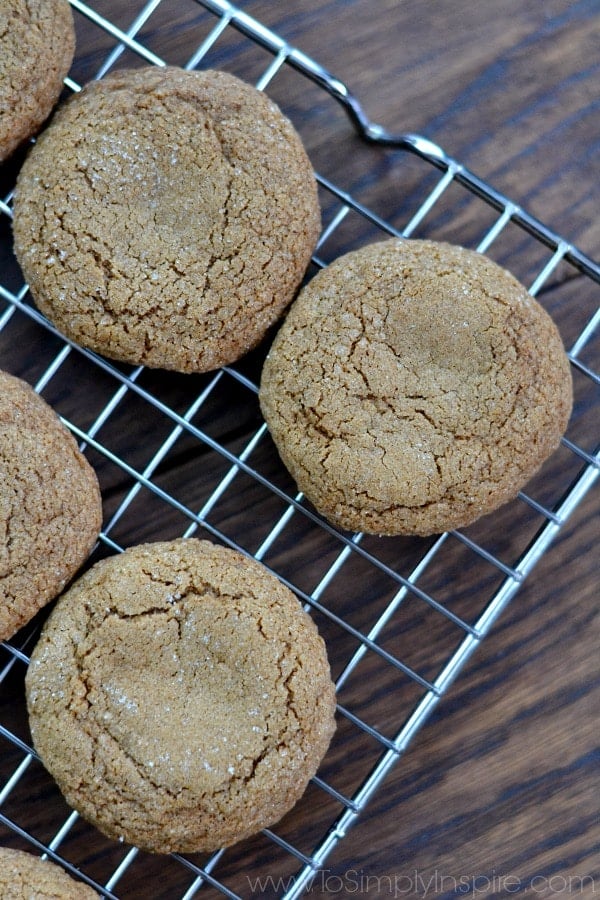 three molasses cookies on a wire cooling rack