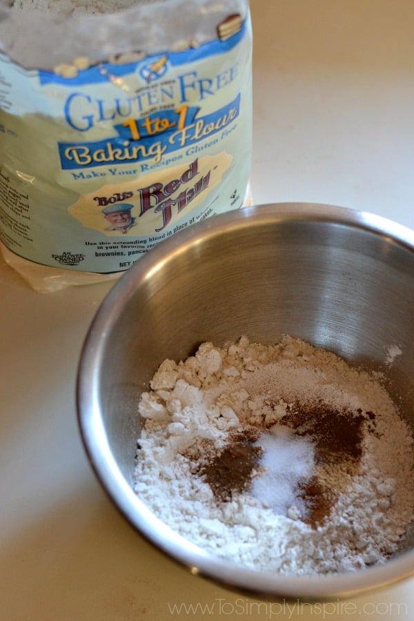 a silver mixing bowl with flour, salt and cinnamon