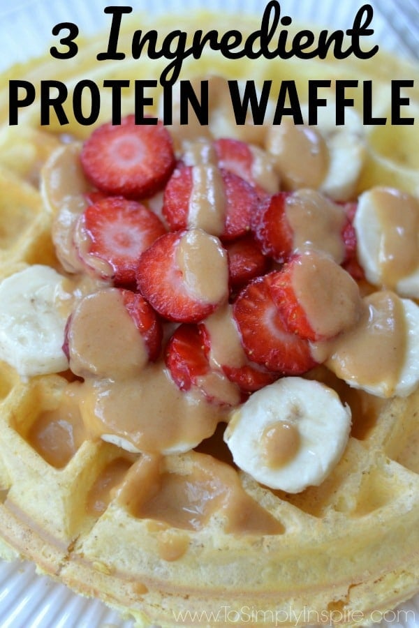 Protein Waffles recipe on a white plate topped with sliced strawberries and bananas drizzled with peanut butter