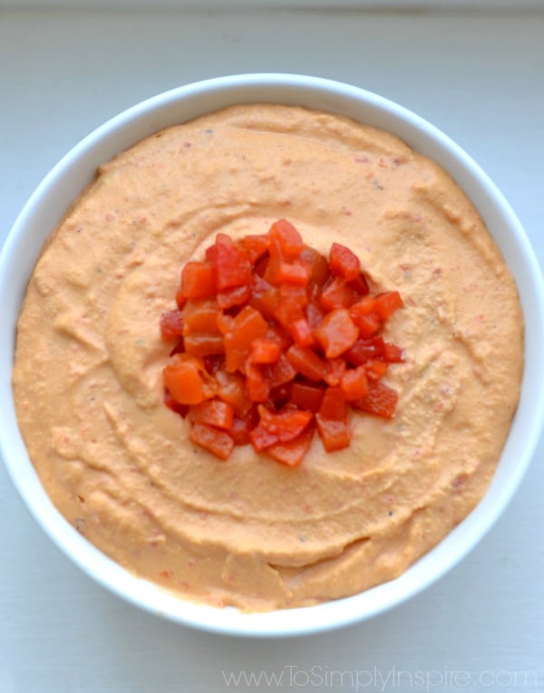 A close up of Hummus topped with roasted red peppers