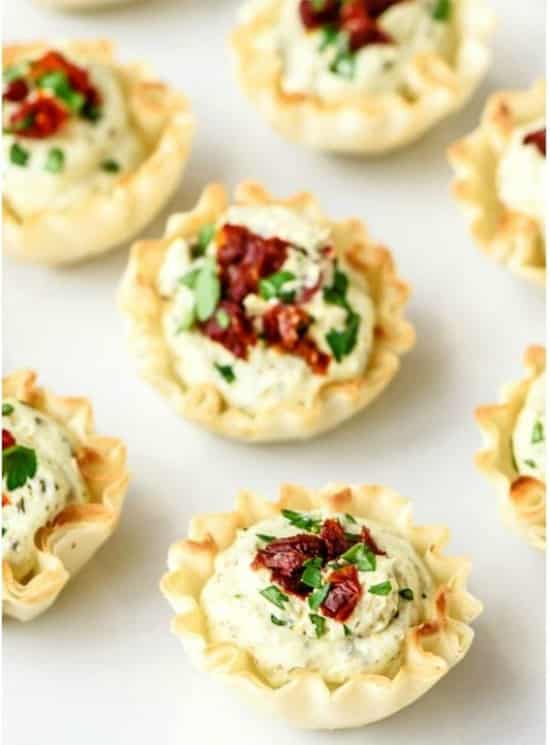 closeup of little cups filled with sundried tomatoes and pesto