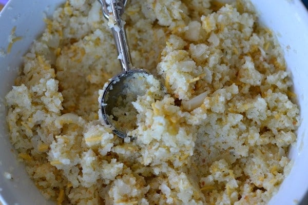 Cauliflower Tots recipe mixture in a white bowl with a spoon