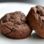 closeup of two chocolate muffins on a white plate