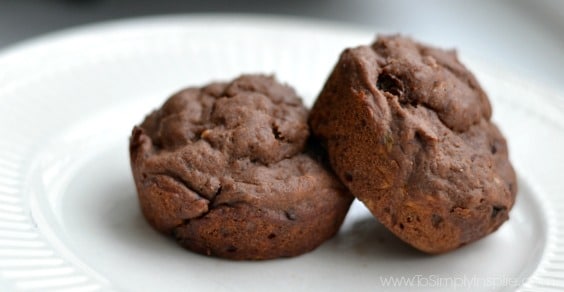 closeup of two chocolate muffins on a white plate