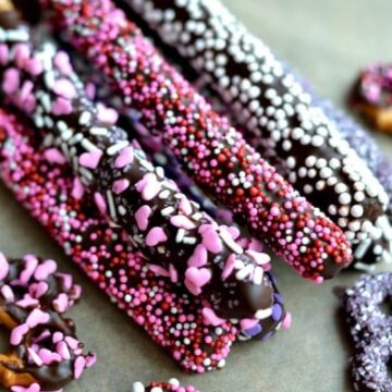 closeup of Chocolate Covered Pretzel rods covered in valentines sprinkles.