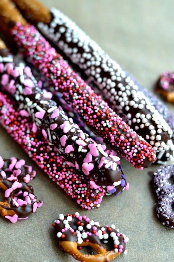 closeup of Chocolate Covered Pretzel rods covered in valentines sprinkles.