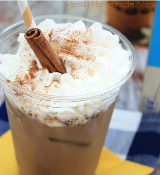 iced coffee topped with whipped cream with a cinnamon stick