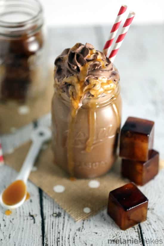 iced coffee on a table with chocolate whipped cream and red and white straw