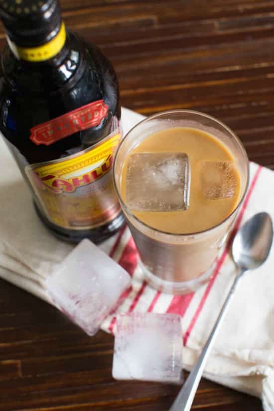 iced coffee in a glass on a red and white towel with kailua bottle beside 