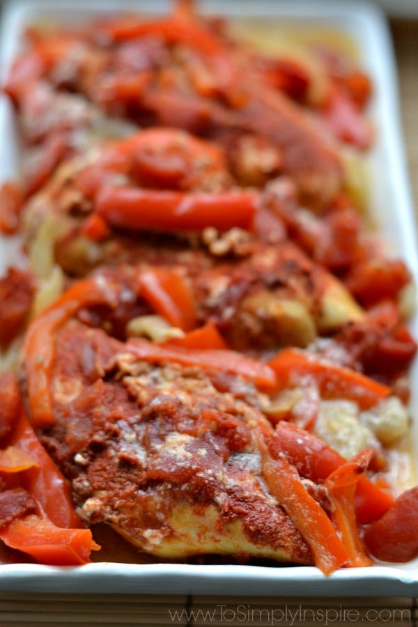 A closeup of Chicken with sliced red bell peppers and paprika