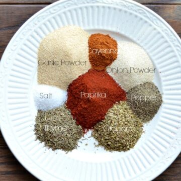 a white plate with piles of spices to make homemade emerils essence seasoning