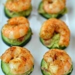 a group shrimp on top of cucumber slices