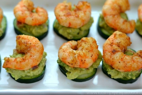 A group of shrimp atop cucumber slices and avocado