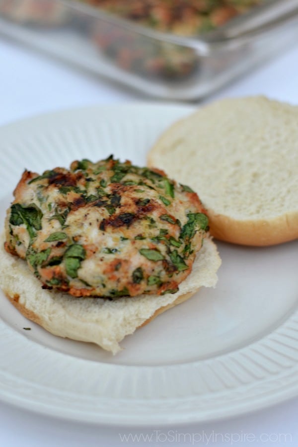 A white plate with a open spinach turkey burger 