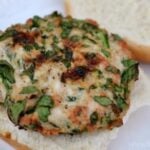 a closeup of a spinach turkey burger on a white plate