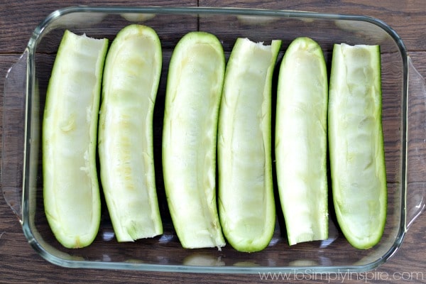 zucchini halves with pulp scooped out in a dish