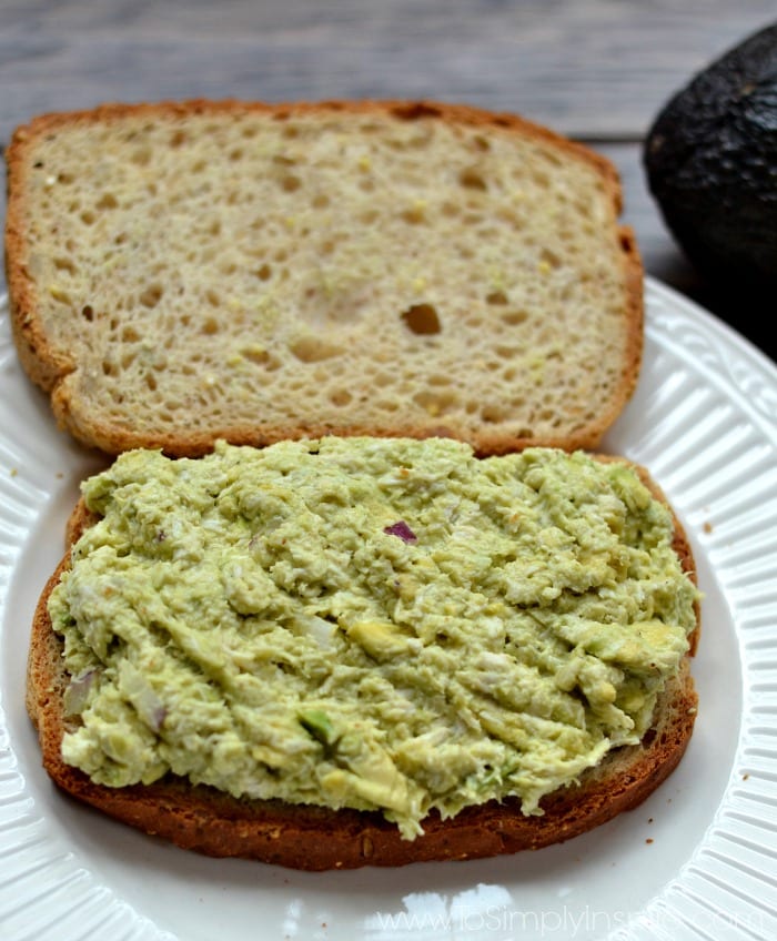 Closeup of Avocado Chicken Salad sandwich opened up and placed on a white plate.