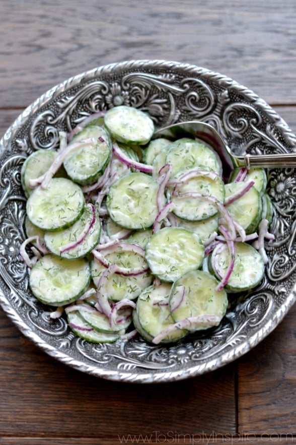 Creamy Cucumber Salad recipe in a big silver bowl with a spoon.