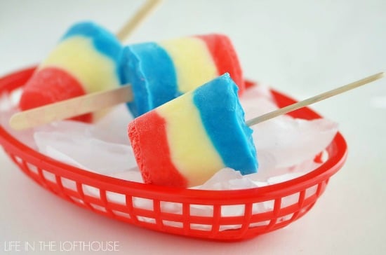 red white and blue layered pudding popsicles in a red plastic basket