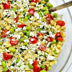 big glass bowl with succotash salad with corn kernels, lima beans and tomatoes