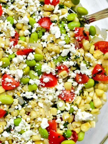 big glass bowl with succotash salad with corn kernels, lima beans and tomatoes