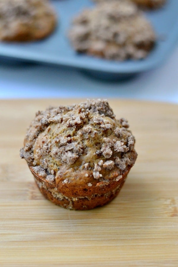 Coffee Cake Muffin on a wood board with muffin tin in background